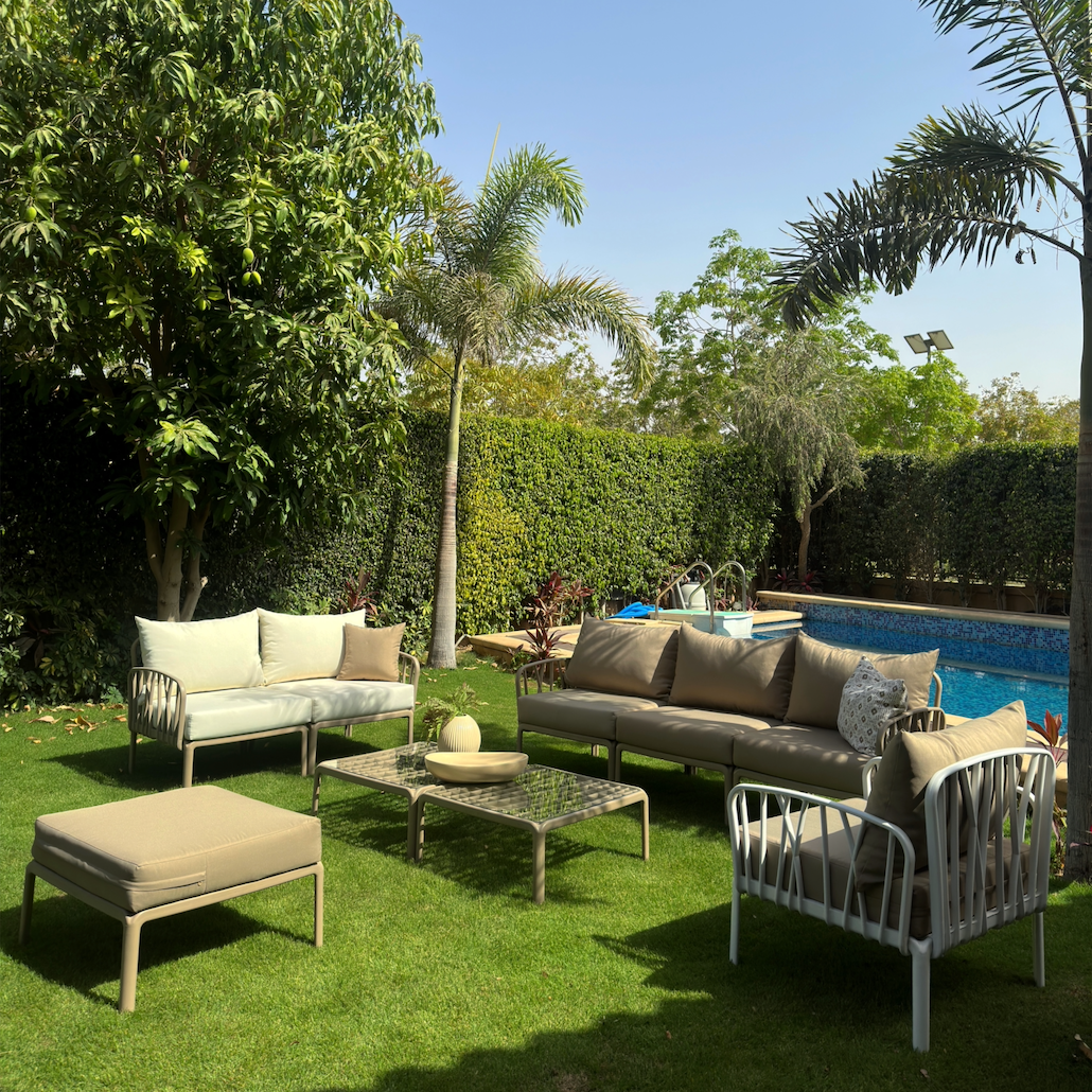 Elegant outdoor furniture set with sofas, chair, pouf, and tables